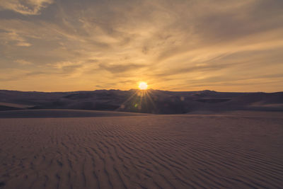 Rippled sand and sand dunes at sunset