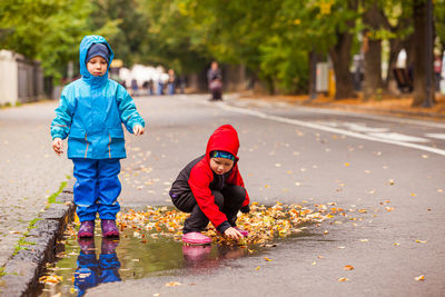 Boy playing with umbrella on street