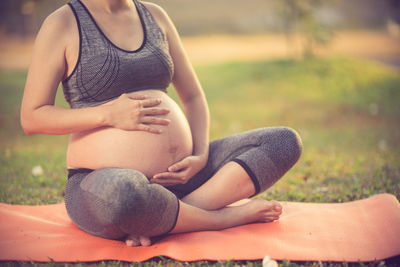 Close-up of pregnant woman sitting outdoors