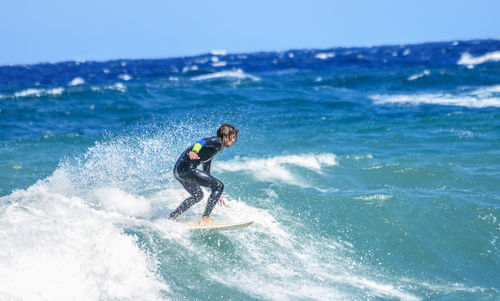 Man surfing in sea against sky