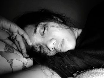 Close-up of baby girl lying on bed