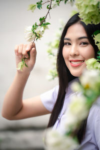 Portrait of a smiling young woman holding flower bouquet