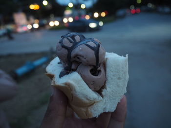 Close-up of hand holding ice cream at night