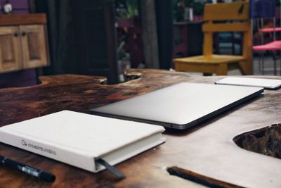 Close-up of book and laptop on table