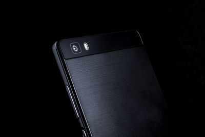 Close-up of mobile phone over black background