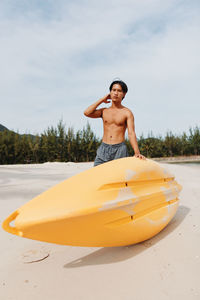 Portrait of young woman kayaking in sea against sky