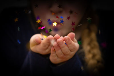 Close-up of hand holding illuminated flowers