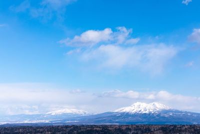 Scenic view of snowcapped mountains against blue sky