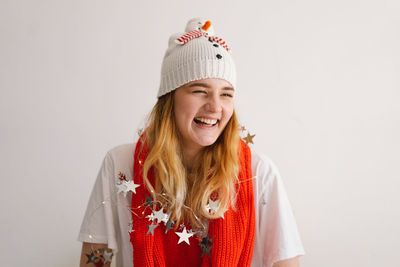 Funny young girl in a christmas hat with a snowman and a red scarf.