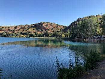 Scenic view of lake against clear blue sky