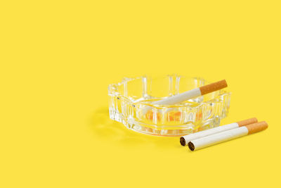 Close-up of cigarette against yellow background