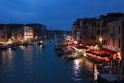 Boats moored in canal at dusk