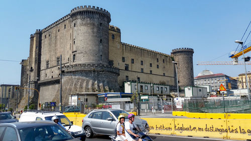 Vehicles on road against buildings in city