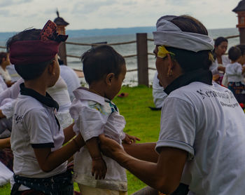 Rear view of people standing in water