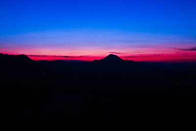 Scenic view of silhouette mountains against sky at sunset