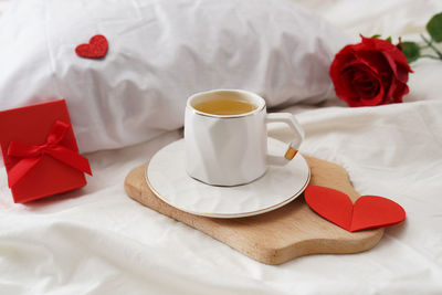 Breakfast in bed cup of green tea, gift box with hearts and roses. valentine's day breakfast in bed