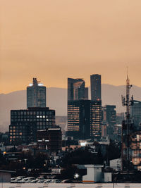 Buildings in city against sky during sunset