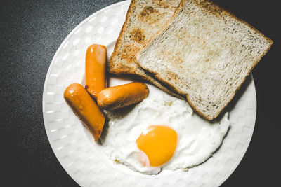 High angle view of breakfast served in plate over black background