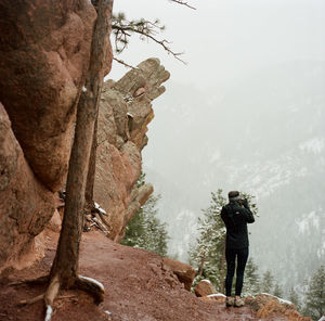 Rear view of man standing on rock