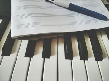 High angle view of piano keys and pen