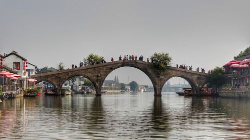 Arch bridge over river against clear sky