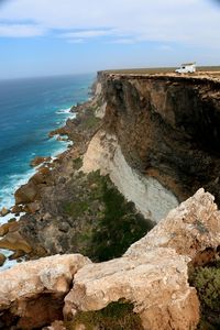 Scenic view of cliff by sea against sky