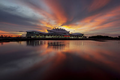 Reflection of illuminated buildings in lake at sunset