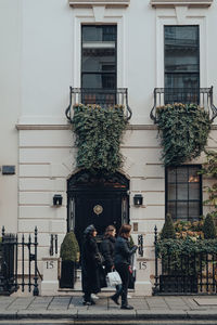 People walking by building in city