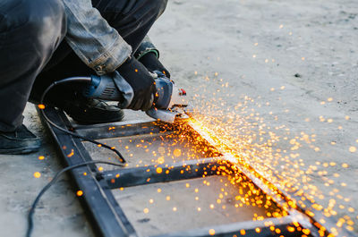 Low section of man working on metal