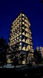 Low angle view of illuminated building against sky at night