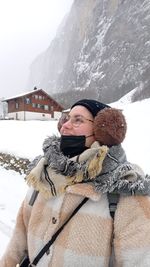 Portrait of young woman standing on snow covered mountain