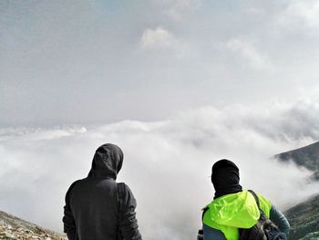 Rear view of people standing on mountain