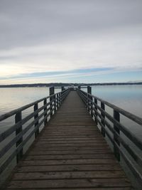 Wooden pier over sea against sky