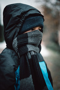 Close-up of boy covering face with scarf