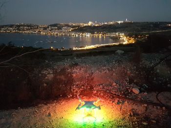Illuminated cityscape against sky at night