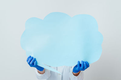 Close-up of woman holding heart shape over white background