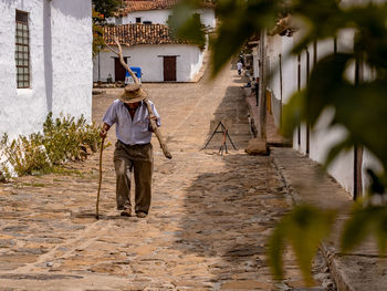 Man carrying wood on footpath in town