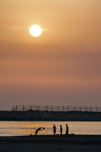 Men at beach during sunset