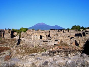 Ruins of buildings against clear blue sky