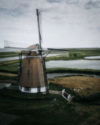 Traditional windmill on landscape against sky