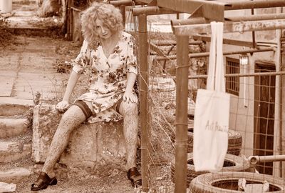 Woman sitting by fence