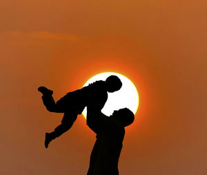 Silhouette men against orange sky during sunset