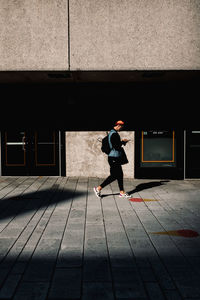 Full length of a man walking on footpath