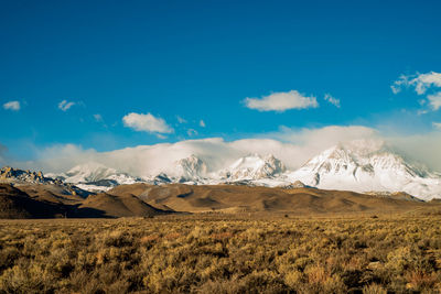 Scenic view of snowcapped mountains against blue sky