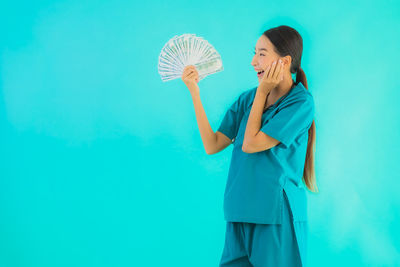 Woman standing against blue background