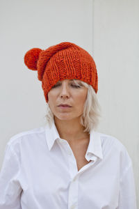 Portrait of smiling young woman wearing hat against white background