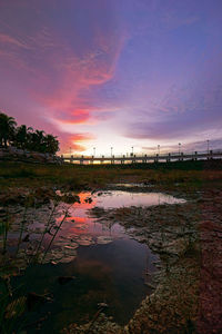 Scenic view of pond against sky during sunset