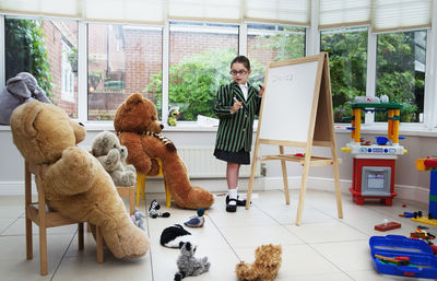 Boy with toy standing by window