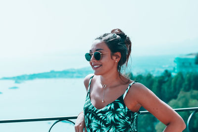 Young woman wearing sunglasses against sea