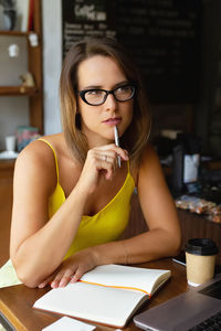 Thoughtful woman sitting at table in cafe